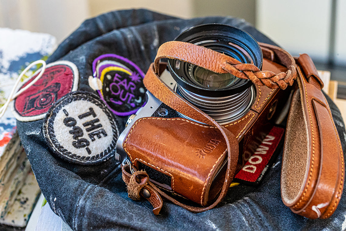 Matériel photo de voyage avec appareil hybride, objectifs et accessoires dans un sac prêt à partir pour capturer des paysages et scènes urbaines