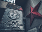Tirage photo DDR Berlin avec plaque métallique Deutsche Demokratische Republik et étoile rouge, ambiance urbaine grise métal et rouge vintage.