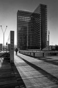 Photographie noir et blanc de la Bibliothèque nationale de France à Paris avec longues ombres au coucher du soleil sur le parvis