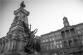 Photo en noir et blanc de la statue d’Infante D. Henrique à Porto, cadrage serré et perspective forte, avec le Palais Da Bolsa en arrière-plan.