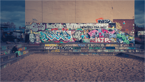 Tirage photo JOE à Berlin avec mur de graffitis variés entre la Spree et East Side Gallery, ambiance urbaine vintage aux couleurs éclatantes.
