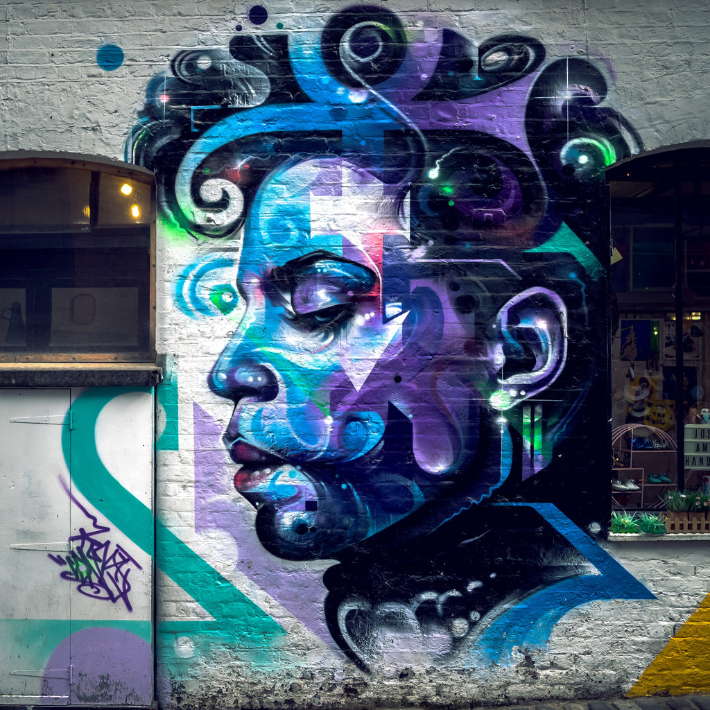 Photo d’un graffiti représentant le chanteur Prince avec son Love Symbol intégré à son visage, peint sur un mur à Camden Town à Londres, avec des tons bleu et violet