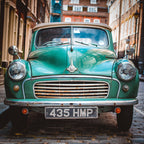 Plonge dans l’atmosphère authentique des rues pavées de&nbsp;Londres avec The Old Morris. Cette photographie capture de face une iconique Morris Minor 1000 Tourer verte, stationnée comme hors du temps.