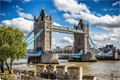 Tower Bridge à Londres sous un ciel bleu avec quelques nuages et des couleurs vives, vue panoramique du pont emblématique