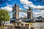 Tower Bridge à Londres sous un ciel bleu avec quelques nuages et des couleurs vives, vue panoramique du pont emblématique
