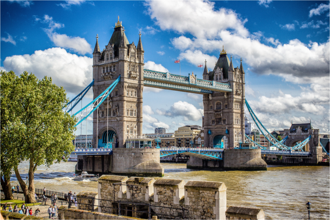 Tower Bridge à Londres sous un ciel bleu avec quelques nuages et des couleurs vives, vue panoramique du pont emblématique