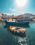 Vue du port antique de Monopoli, bateau de pêche et barque typique, ciel bleu et soleil brillant sur l’eau, journée d’été, Pouilles, Italie